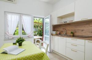 a kitchen with a table with a yellow table cloth at Garden House Premantura in Premantura
