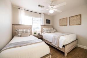 two beds in a bedroom with a ceiling fan at Gilbert Douglas in Gilbert +38 photos