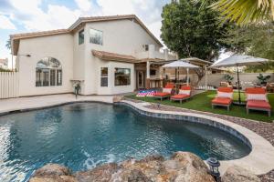 a swimming pool in front of a house at Gilbert Beachcomber in Gilbert