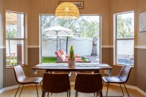 a dining room with a table and chairs and a potted plant at Gilbert Beachcomber in Gilbert