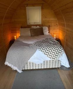 a bedroom with a bed in a wooden cabin at Orchard Pod in Oswestry