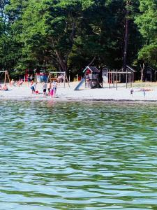 a group of people on a beach near the water at RYMLIG RENOVERAD GÄSTBOSTAD med egen ingång nära stranden i HÄLLEVIK in Sölvesborg