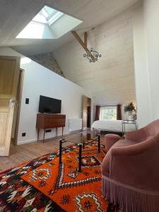 a living room with a bed and a couch and a table at La maisonnette in Saussemesnil