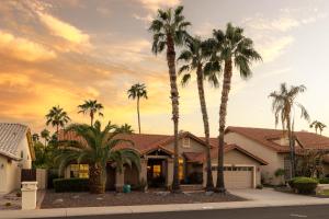 a house with palm trees in front of a sunset at Glendale Sack in Glendale