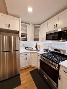 a kitchen with white cabinets and a stainless steel refrigerator at BP STAYS - Hotel-Style, No Host, Professionally Managed ID312 in Jersey City +58 photos