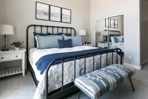 a bedroom with a bed with blue pillows and a mirror at Mesa Palms Ferro in Mesa +25 photos
