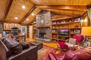 a living room with a stone fireplace and leather furniture at Wildwood in Townsend