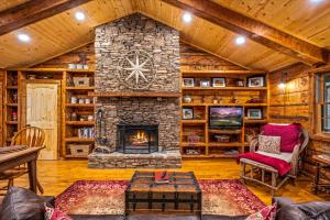 a living room with a stone fireplace in a cabin at Wildwood in Townsend