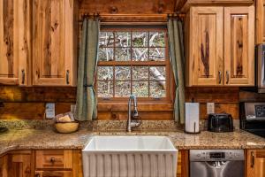 a kitchen with a sink and a window at Wildwood in Townsend +22 photos