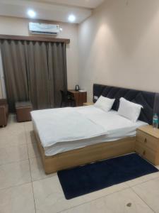 a bedroom with a large bed with white sheets at Kanti empire in Dhaulpur +21 photos