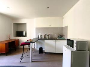 a kitchen with a counter and a microwave and a table at L'aube de Pierre in Saint-Pons-de-Thomières