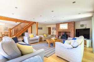 a living room with white furniture and a fireplace at 4 Bed in Fakenham oc-1261 in Thursford