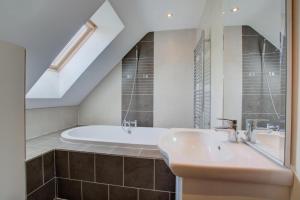 a bathroom with a sink and a bath tub at 4 Bed in Fakenham oc-1261 in Thursford +15 photos