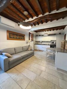 a living room with a couch and a kitchen at Casetta di pisolo in Pistoia