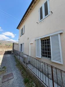 a white building with a fence in front of it at Casetta di pisolo in Pistoia