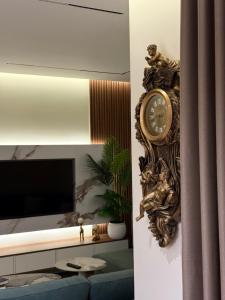 a clock hanging on a wall next to a tv at Modern Luxury Apartment-City Center-Walk Anywhere in Durrës