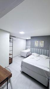 a bedroom with two beds and a table and a desk at Hotel Novo Sol in Petrolina +18 photos