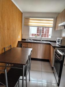 a kitchen with a table and a sink and a stove at Tronador I in Puerto Montt