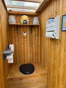 Ein Badezimmer aus Holz mit Toilette und Waschbecken in der Unterkunft Forest Camping with grillhouse and dush in Lõupõllu + 22 Fotos