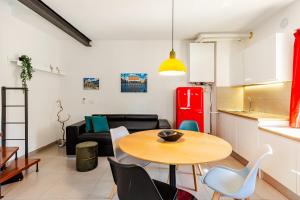 a living room with a table and a kitchen at Dimora Sant Anna in Piacenza