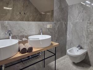 ein Badezimmer mit zwei Waschbecken und einer Toilette in der Unterkunft Parko7 apartamentai in Plateliai