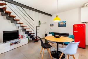 a living room with a table and chairs and a red refrigerator at Dimora Sant Anna in Piacenza