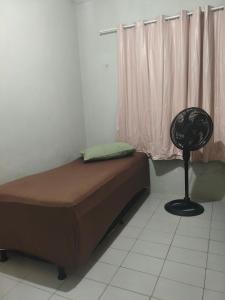 a bedroom with a bed and a fan next to a window at Pousada Bom Jesuss in Juazeiro do Norte