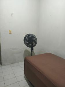 a fan sitting next to a bed in a room at Pousada Bom Jesuss in Juazeiro do Norte +1 photo