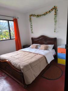 a bedroom with a bed with a garland on the wall at Hostal La Clarita in Fusagasuga