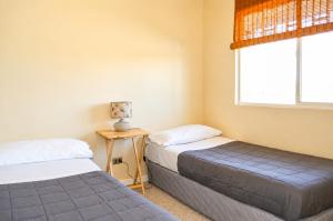 two beds in a room with a window at Tronador I in Puerto Montt