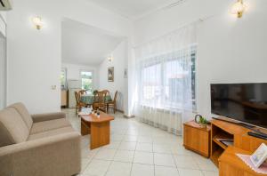 a living room with a couch and a tv at Garden House Premantura in Premantura