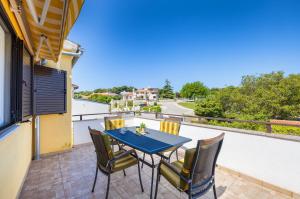 a patio with a table and chairs on a balcony at Garden House Premantura in Premantura