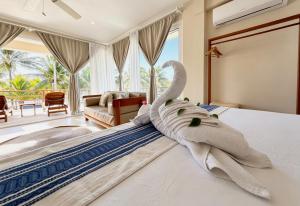 a bedroom with a towel animal laying on a bed at Noah Beach Hotel & Suites in Mahahual