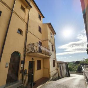a building with a balcony on the side of it at Tuscan Sunsets Tramonti Toscani in Fauglia