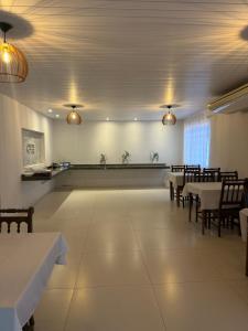 a dining room with tables and chairs and lights at Hotel Pintado Azul in Coxim