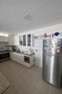 a kitchen with a stainless steel refrigerator and a microwave at DunnaAP Smart Studios in Catalão