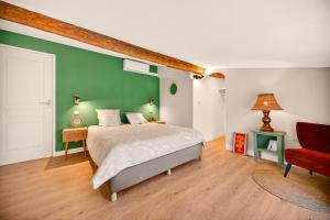 a bedroom with a bed and a green wall at Pigeonnier de charme in Villefranche-de-Lauragais