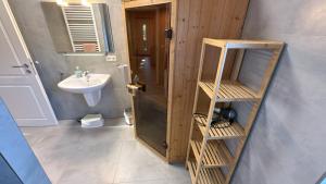 a bathroom with a sink and a wooden door at Bauernhof Claussen Fehmarn in Fehmarn +164 photos