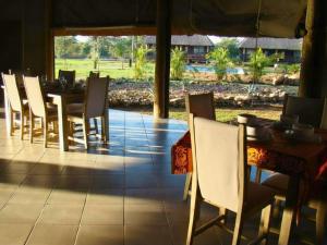 a dining room with a table and chairs at Chobe Lesoma Chalets Hotel in Lesoma