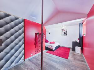a bedroom with a red door and a bed with a red rug at L'instant secret in Berlaimont