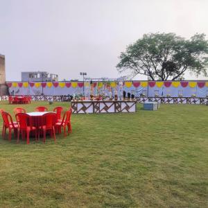 a group of red chairs and a table in a field at Kanti empire in Dhaulpur