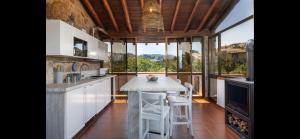 a kitchen with a counter and a table with stools at Seafront wow appartamento Baja Sardinia in Baja Sardinia