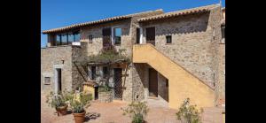 a large stone building with a staircase on it at Seafront wow appartamento Baja Sardinia in Baja Sardinia