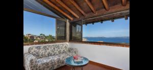 a living room with a couch and two large windows at Seafront wow appartamento Baja Sardinia in Baja Sardinia +5 photos
