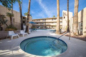 a pool with a hot tub in a courtyard with palm trees at Scottsdale Miller in Scottsdale