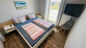 a small room with a bed and a television at Bauernhof Claussen Fehmarn in Fehmarn