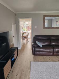 a living room with a brown leather couch and a table at Modern living in Hull in Hull