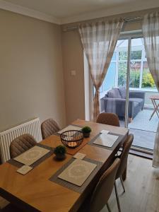 a dining room table with chairs and a large window at Modern living in Hull in Hull