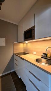 a kitchen with a sink and a microwave at Ferienwohnung Pollig in Rech