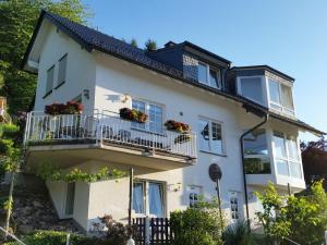 a white house with balconies and flowers on it at Ferienwohnung Pollig in Rech